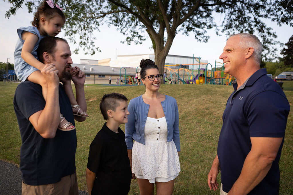 Image of Joe Emrick speaking with a young family
