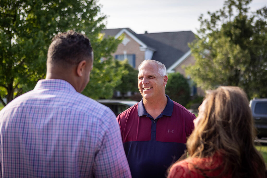 Image of Joe Emrick speaking with his constituents outside their home